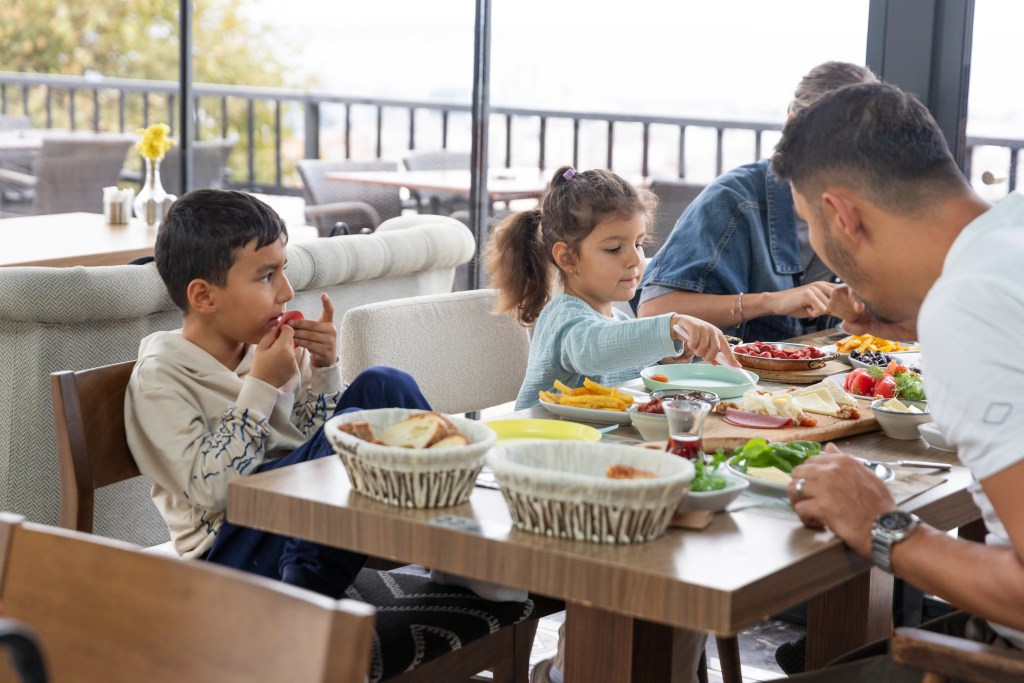 Filifu Cafe’de deniz manzaralı serpme kahvaltı keyfi yapan aile