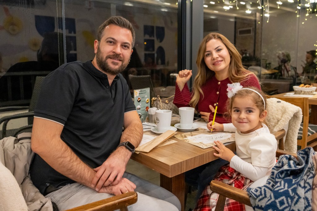 Anne, baba ve çocuk, Filifu Cafe’de yemek masasında keyifli bir yemek yiyor.