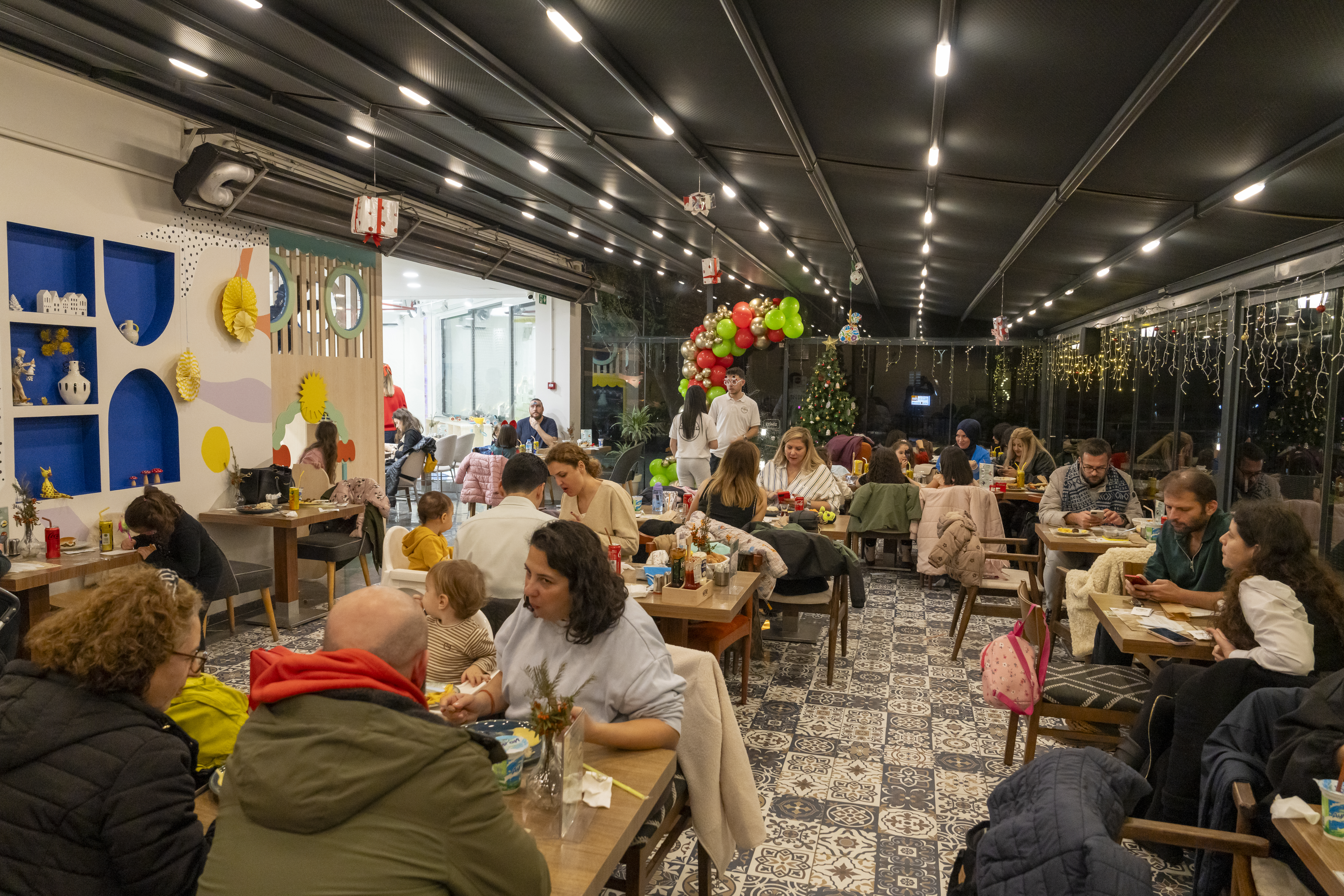 Filifu Cafe'de özel bir etkinlik sırasında yemek yiyen kalabalık grup