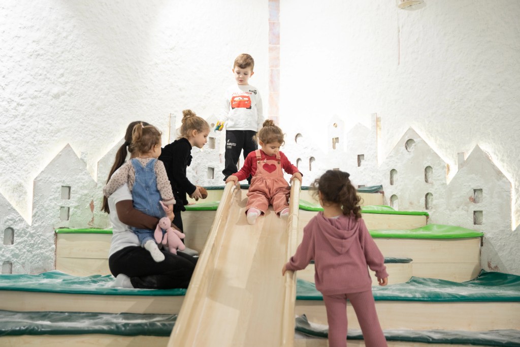 Doğum günü partisine gelen çocuklar, Filifu Cafe'nin tuz odasındaki kaydıraktan kayarak eğleniyor.