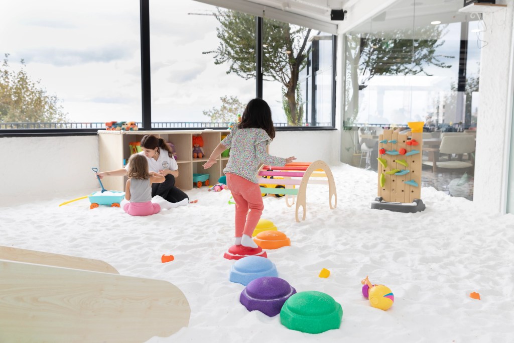 Geniş ve ferah tuz odasında oyuncaklarla oynayan mutlu bir çocuk.