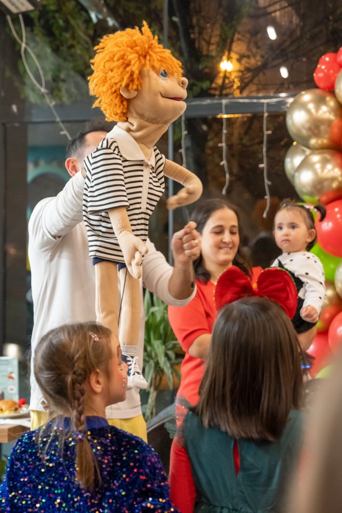 Çocuklar doğum günü partisinde kukla Fili ile eğleniyor.