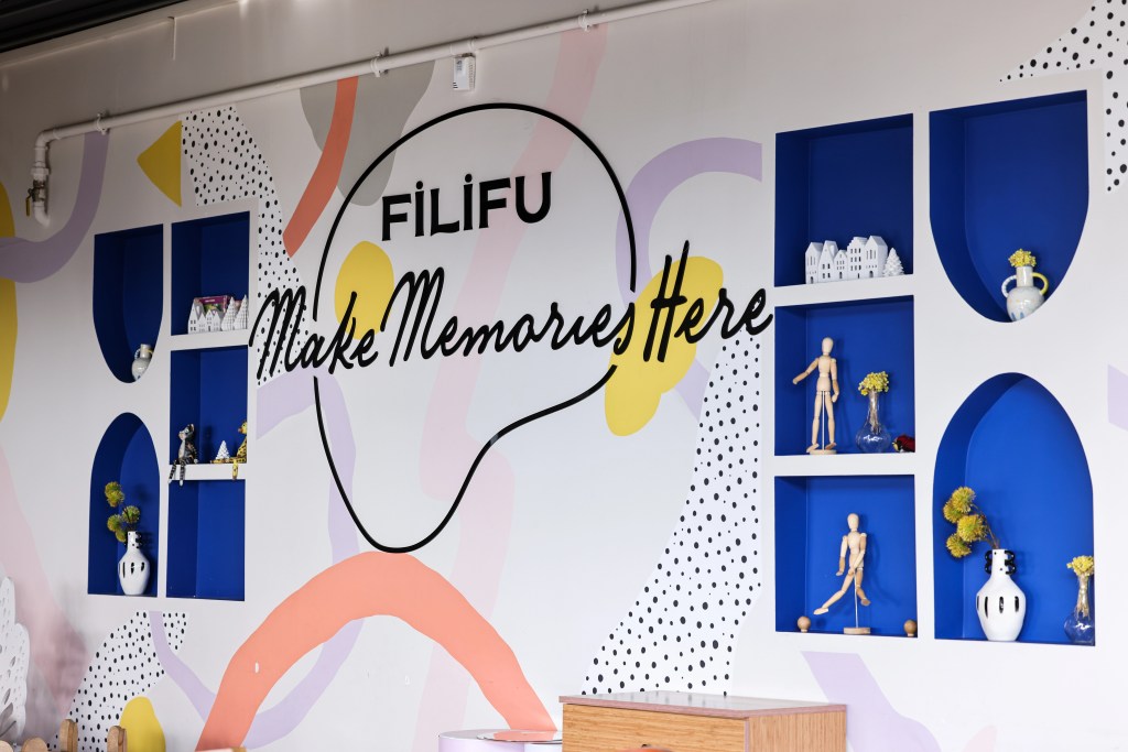 Filifu kafe iç mekan dekoru: "Make Memories Here" sloganı, mavi nişler, çiçekler ve figürinlerle doğum günü etkinlikleri için hazır mekan.