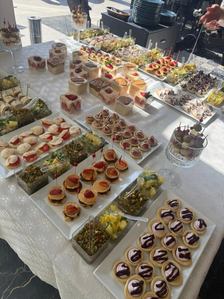 Birthday party catering table with mini desserts, fruit cups, pancakes, and savory snacks prepared for a children’s birthday celebration at Filifu Cafe N’ Play.