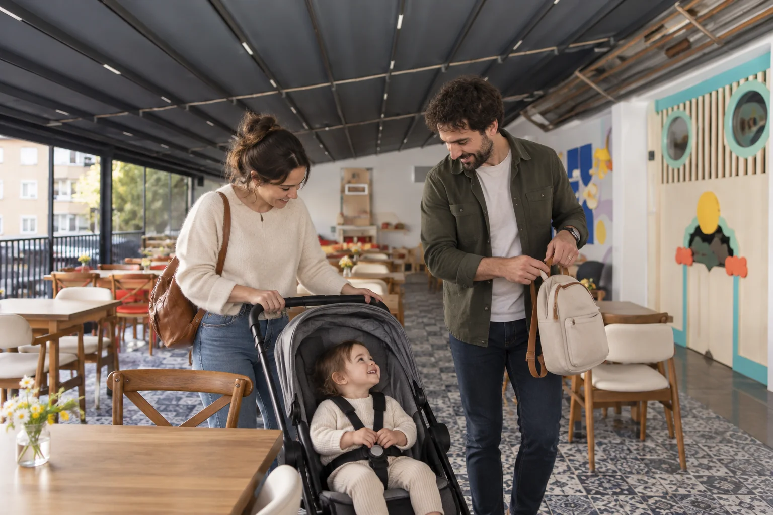 Zwei Erwachsene bereiten neben einem Kind im Kinderwagen ihre Tasche für den Aufbruch vor