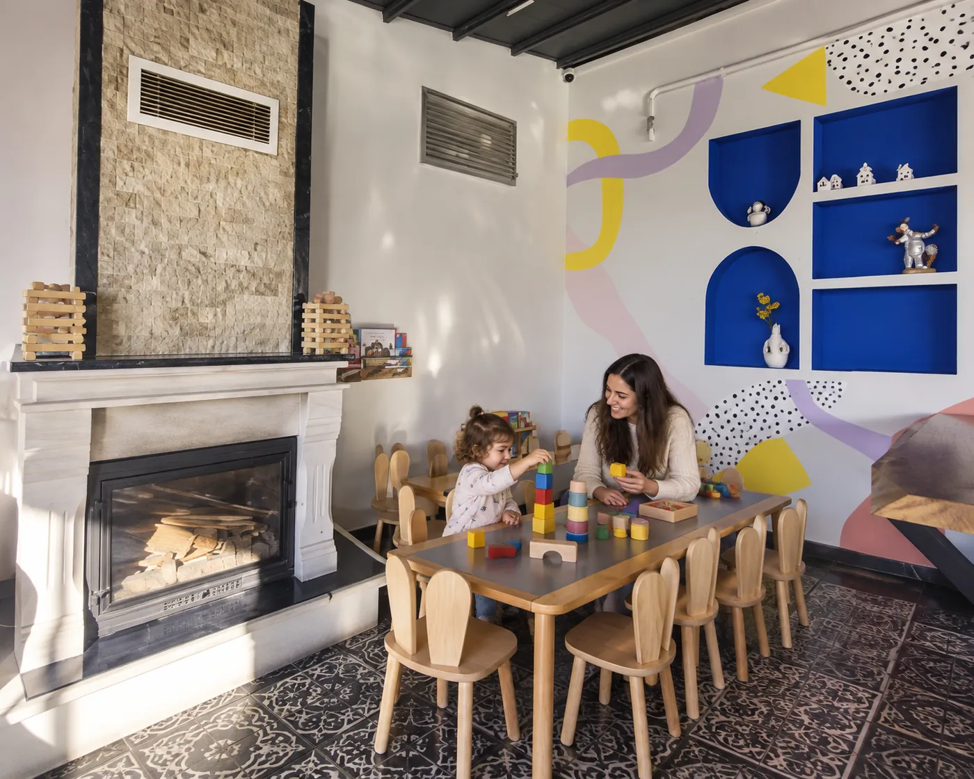 Un genitore e un bambino esplorano grandi costruzioni colorate in un ambiente ispirato a Filifu Cafe