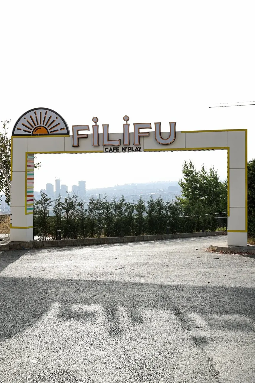 واجهة لافتة Filifu Cafe N’Play داخل إطار أبيض وأصفر عند المدخل