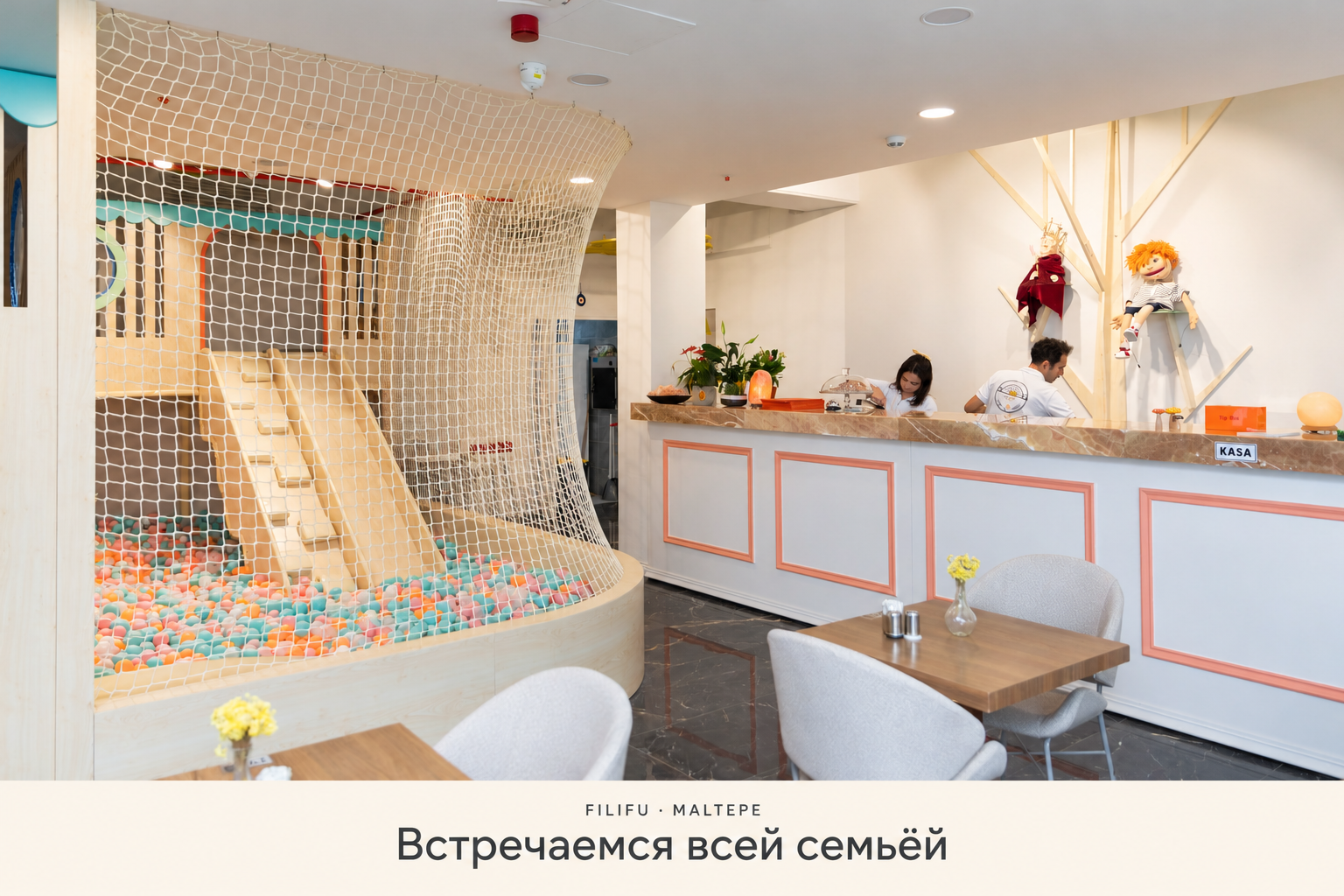 Столики Filifu рядом с сетчатым ограждением детской игровой зоны и стойкой кафе